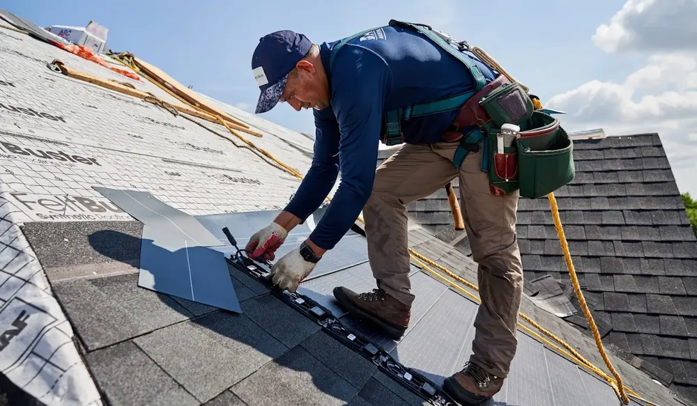 Roofer repairing shingles and fixing a leak